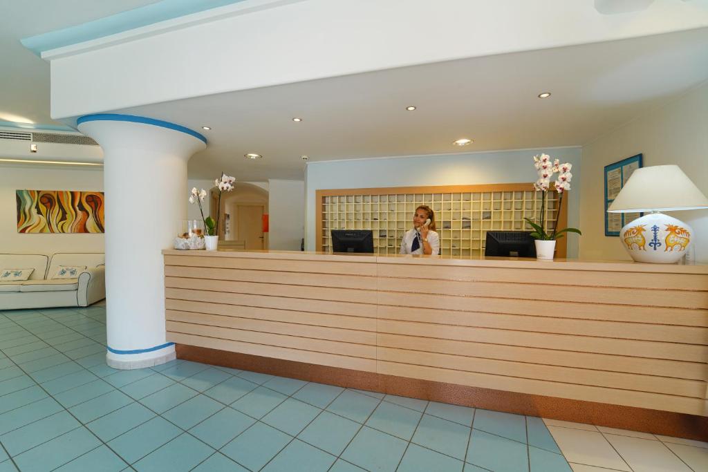 une femme debout à la réception dans le hall dans l'établissement Hotel La Caletta Village, à La Caletta 113 autres photos