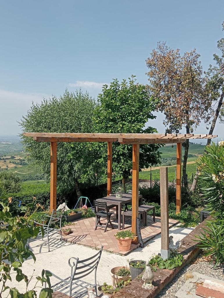 une pergola en bois avec une table et des chaises dans l'établissement NiFe Tiny House - Secret Garden, à Montalbo