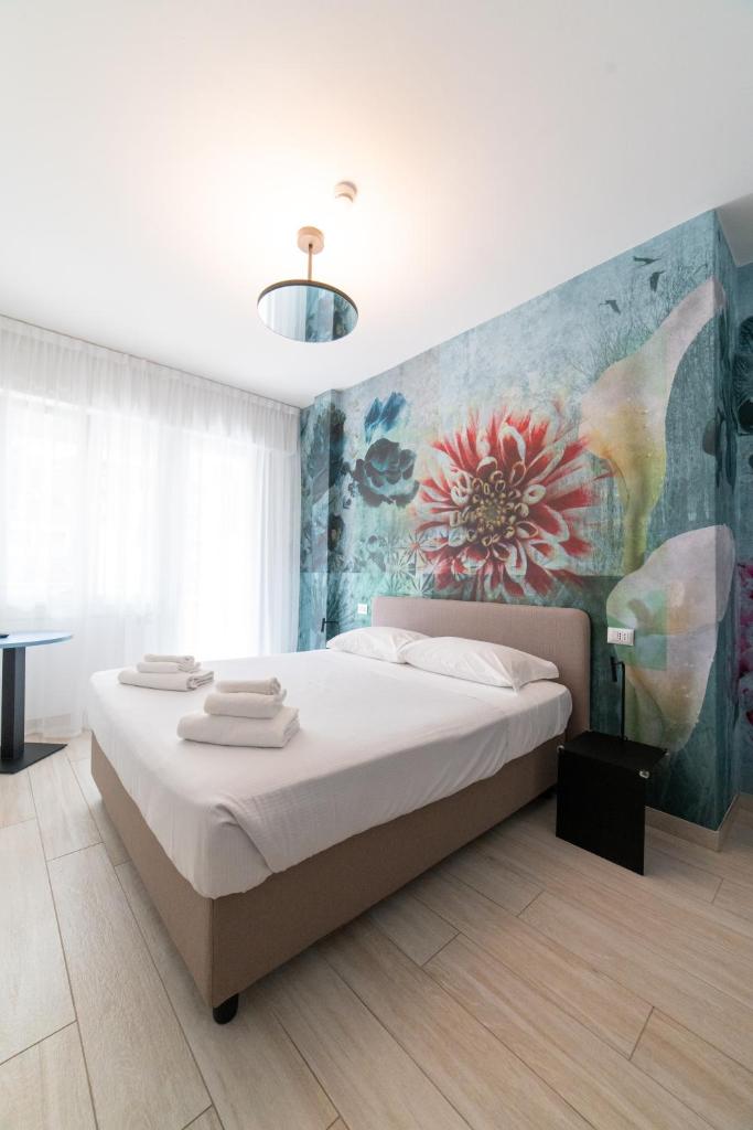 une chambre avec un lit et un tableau au mur dans l'établissement Lilium Maris Hotel, à Bibione