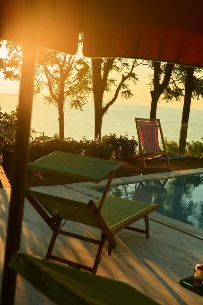 - une table et une chaise à côté de la piscine dans l'établissement Hidden Dalla Gioconda, à Gabicce Mare