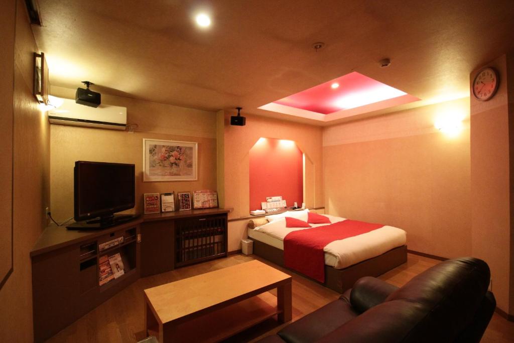 Cette petite chambre comprend un lit et une télévision. dans l'établissement マイルームーmy roomー,  2 autres photos