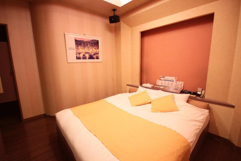 une chambre avec un grand lit avec des oreillers jaunes dans l'établissement マイルームーmy roomー,