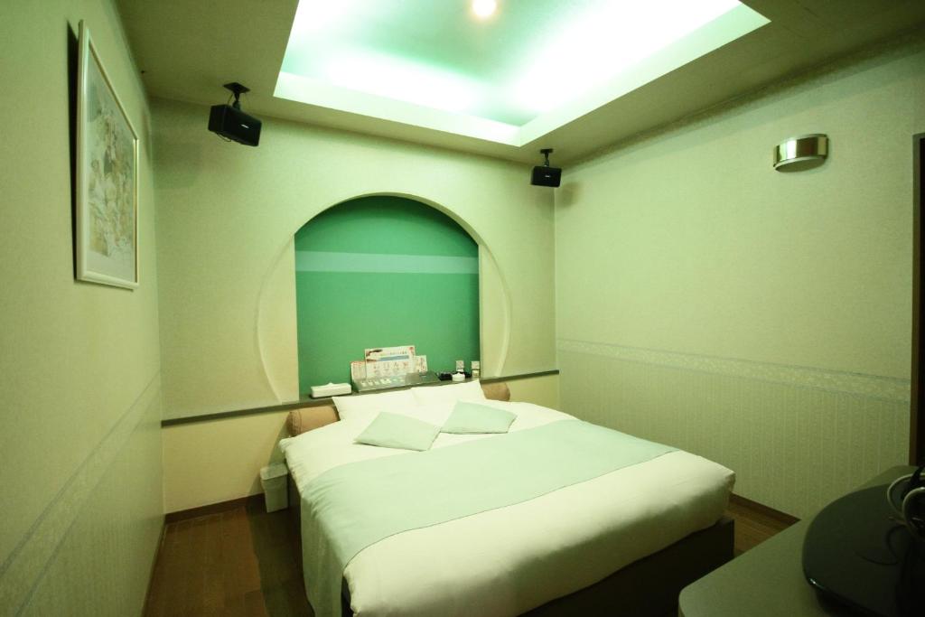 une chambre avec un grand lit blanc dans une pièce dans l'établissement マイルームーmy roomー,