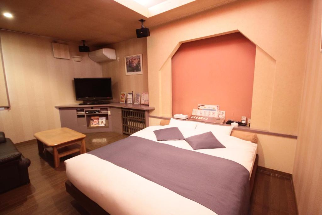 une chambre avec un grand lit et une télévision à écran plat dans l'établissement マイルームーmy roomー,