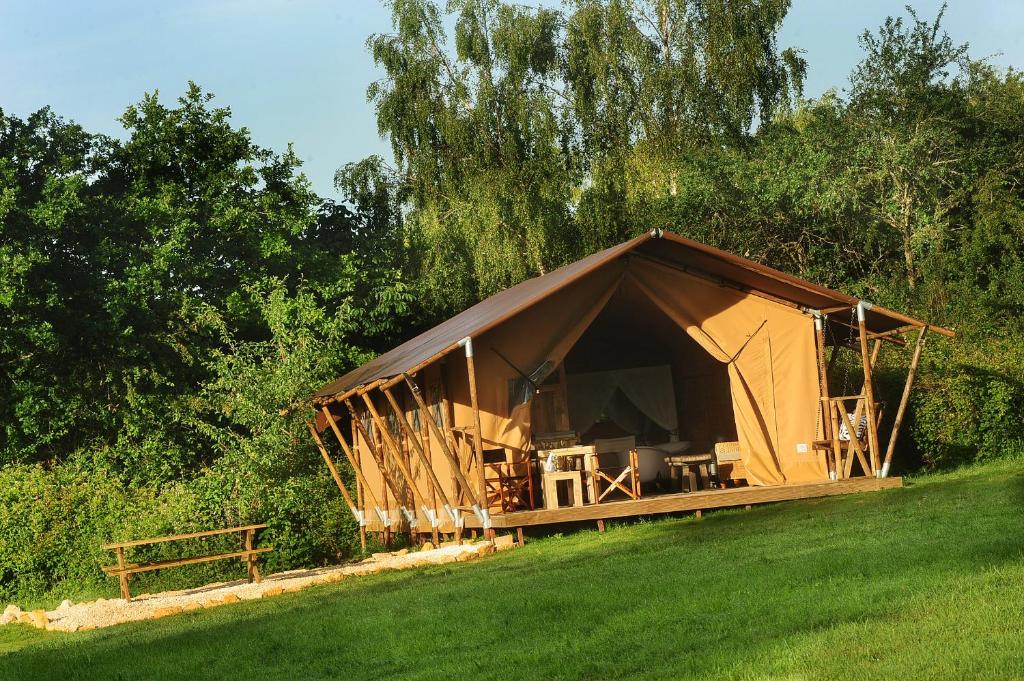 une grande tente dans un champ à côté des arbres dans l'établissement Kimaro Farmhouse, à Colméry