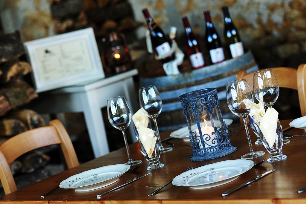 - une table avec des verres à vin, des serviettes et des bouteilles de vin dans l'établissement Kimaro Farmhouse, à Colméry 36 autres photos
