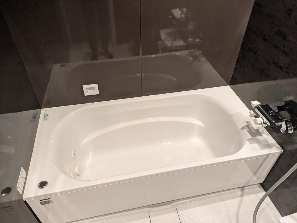 La salle de bains est pourvue d'une baignoire blanche. dans l'établissement マイルームーmy roomー,