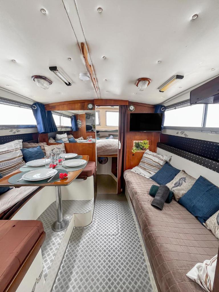 un salon avec une table et un canapé dans l'établissement Nuit Insolite sur un Bateau au Cœur de Bordeaux, à Bordeaux
