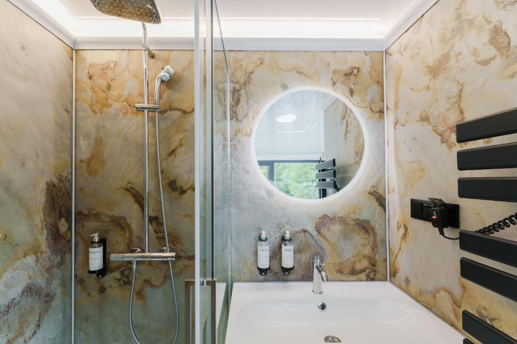 une salle de bain avec une douche, un lavabo et un miroir dans l'établissement L'Escale Royale Saint-Fargeau-Ponthierry - Seine - Melun, à Boissise-le-Roi 33 autres photos