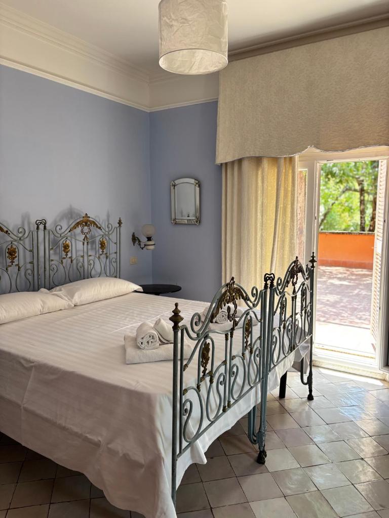 - une chambre dotée d'un grand lit avec des draps blancs et une fenêtre dans l'établissement Luxury Villa - Appia Antica, à Rome