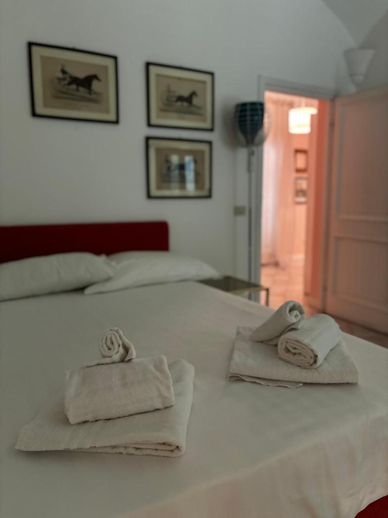 un lit blanc avec des serviettes dessus dans l'établissement Luxury Villa - Appia Antica, à Rome