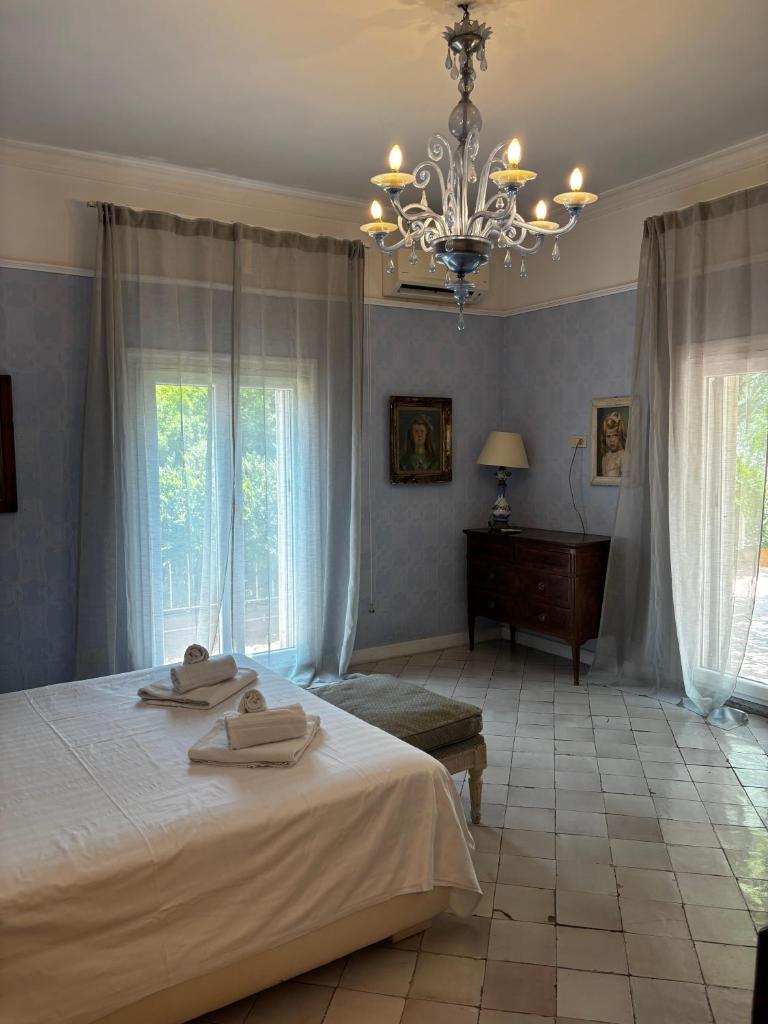 une chambre avec un grand lit et un lustre dans l'établissement Luxury Villa - Appia Antica, à Rome 157 autres photos