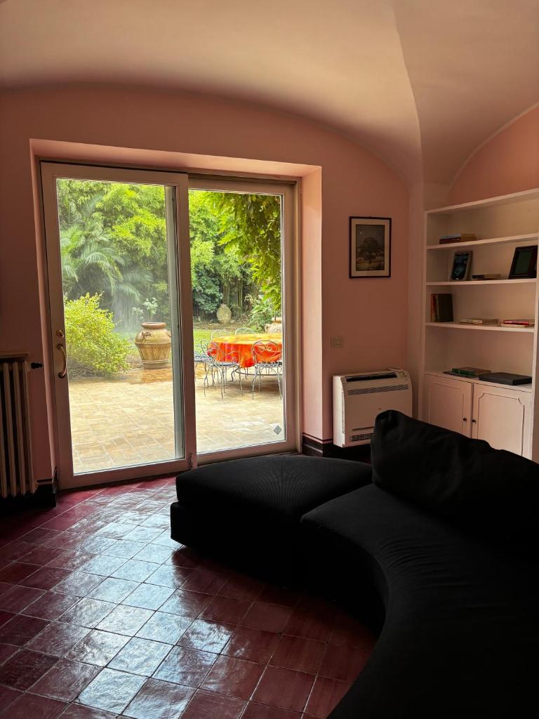 un salon avec un canapé et une porte coulissante en verre dans l'établissement Luxury Villa - Appia Antica, à Rome