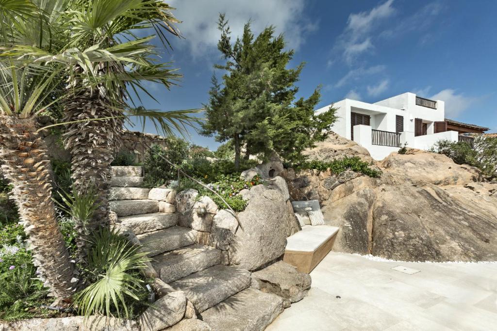 un escalier en pierre devant une maison avec des palmiers dans l'établissement Villa Azzurra con vista mozzafiato, à Porto Cervo