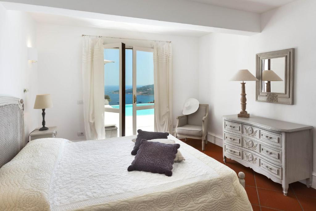une chambre avec un lit et une vue sur l'océan dans l'établissement Villa Azzurra con vista mozzafiato, à Porto Cervo