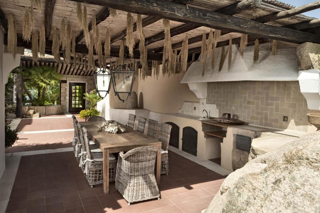 une cuisine extérieure avec une table et des chaises en bois dans l'établissement Villa Azzurra con vista mozzafiato, à Porto Cervo