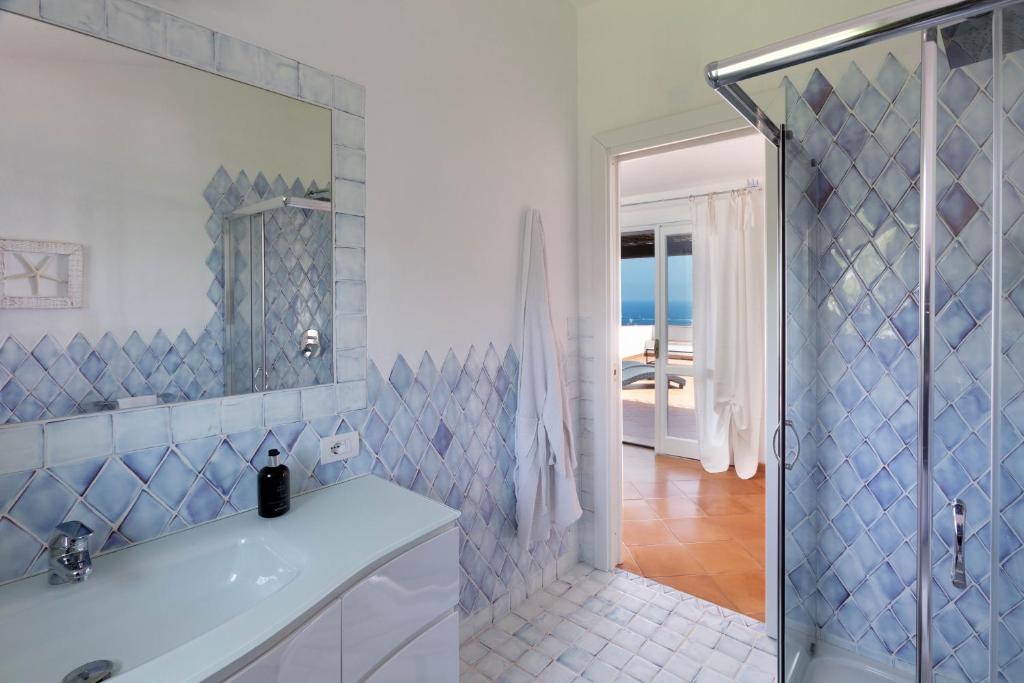 une salle de bain blanche avec une douche et un lavabo dans l'établissement Villa Azzurra con vista mozzafiato, à Porto Cervo