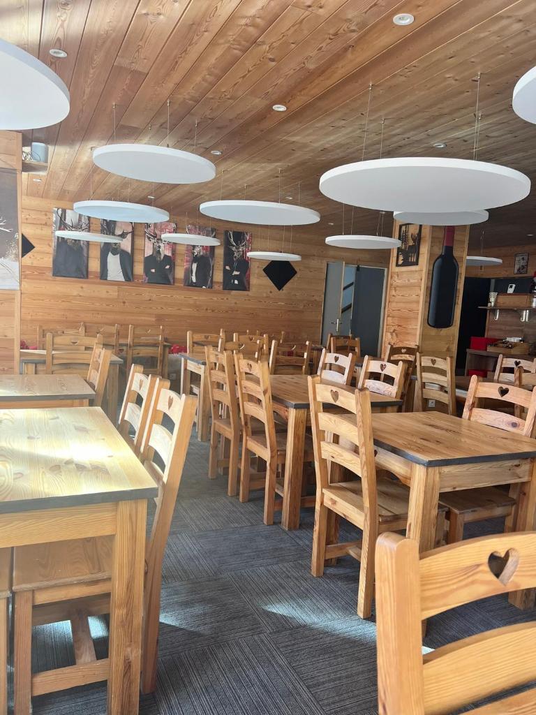 une salle à manger avec des tables et des chaises en bois dans l'établissement Hôtel l'Équipe, au Sauze