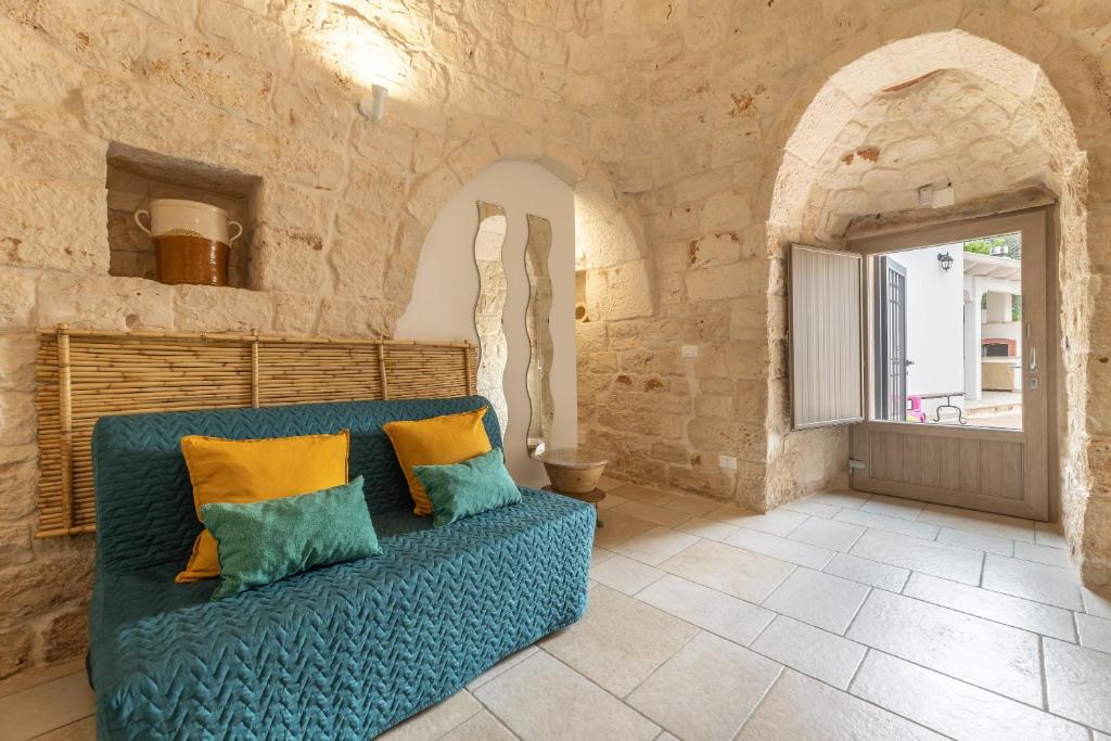 un canapé bleu dans une pièce avec une fenêtre dans l'établissement Trullo Aia Antica, à Ceglie Messapica