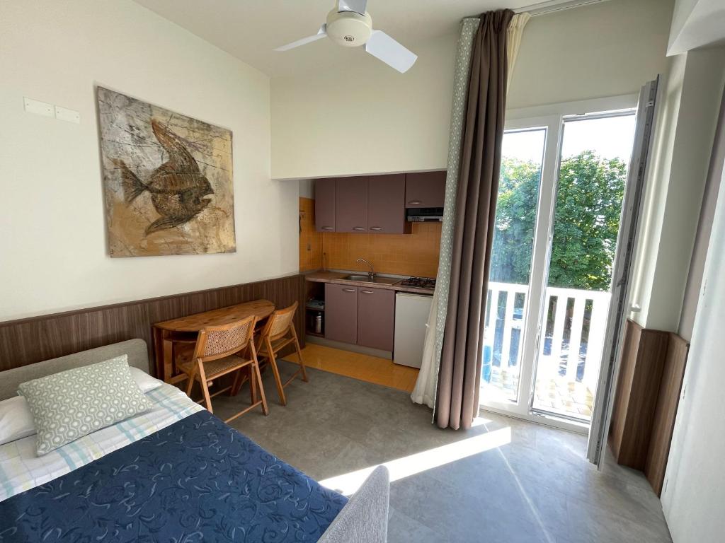 Cet appartement comprend une chambre avec un lit et une cuisine avec une fenêtre. dans l'établissement Hotel Everest - Bar e Ristorante, à Gabicce Mare