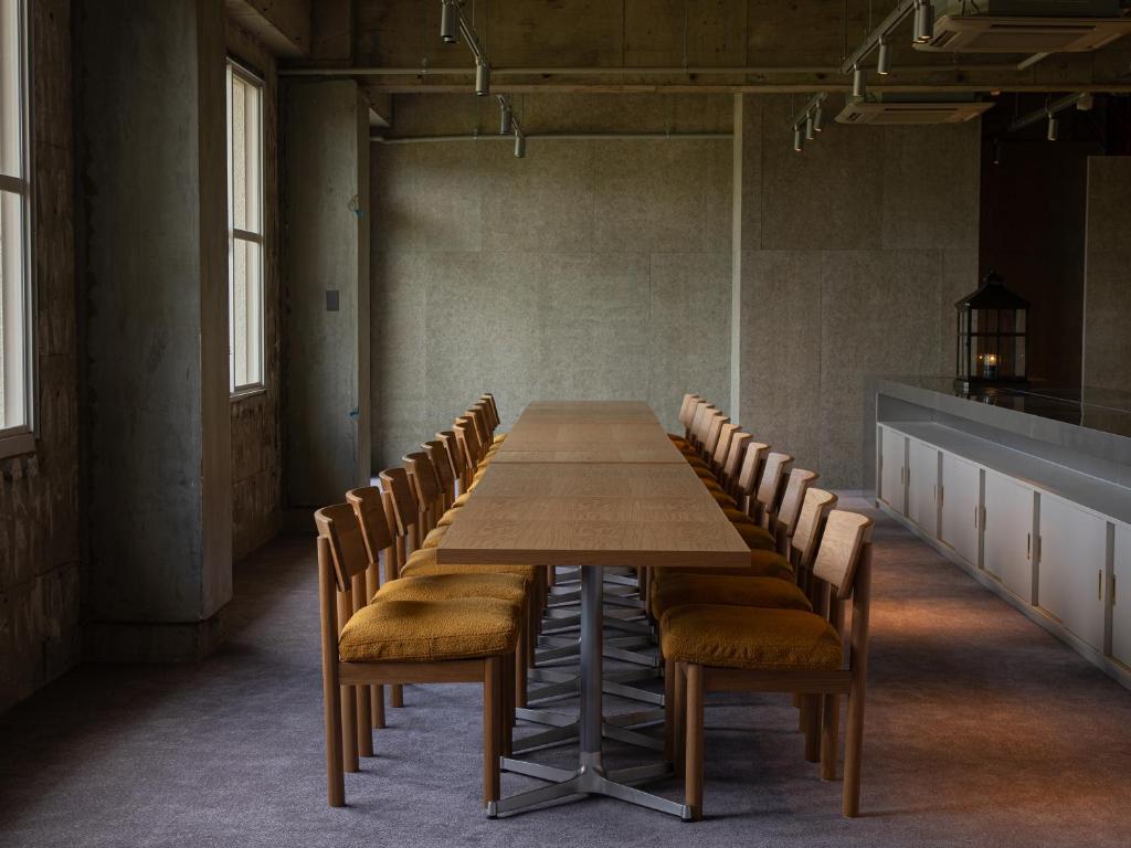 une longue table et des chaises dans une pièce vide dans l'établissement ONCRI-Karatsu おんくり唐津, à Karatsu