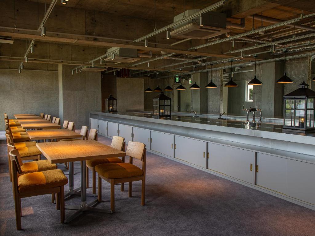 une rangée de tables et de chaises dans une pièce dans l'établissement ONCRI-Karatsu おんくり唐津, à Karatsu