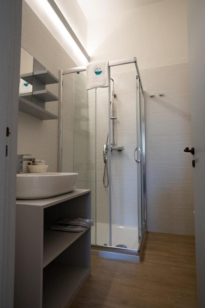 une salle de bain avec une douche en verre et un lavabo dans l'établissement Lido degli Angeli Case Vacanza-Beach, à Punta Prosciutto