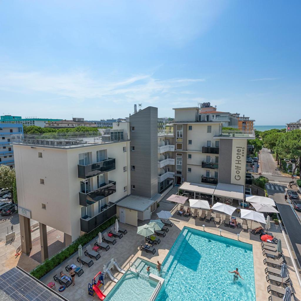 une vue aérienne sur un hôtel avec une piscine et des bâtiments dans l'établissement Hotel Golf ***S, à Bibione