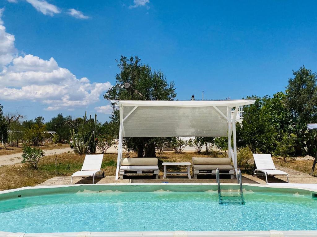 - une piscine avec un kiosque, une table et des chaises dans l'établissement Casina del mandorlo Private Pool, à Maglie