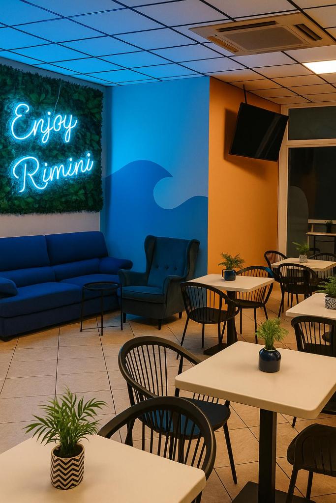 un restaurant vide avec des tables et des chaises et une enseigne au néon dans l'établissement Hotel Aldebaran, à Rimini