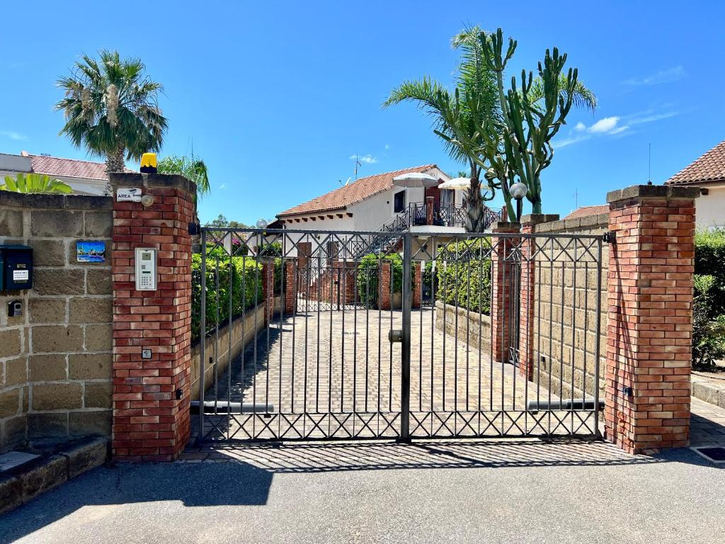 une porte menant à une maison avec des palmiers derrière elle dans l'établissement Villa Camelie, à Campofelice di Roccella