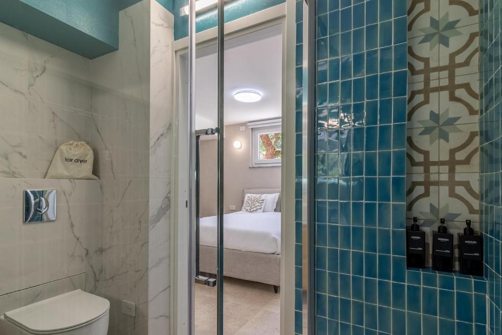une salle de bain avec douche et toilettes et un lit dans l'établissement Villa Amaranta, à La Spezia
