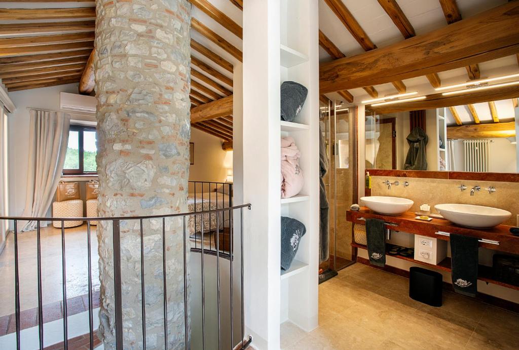 une salle de bain avec deux lavabos et un pilier en pierre dans l'établissement Casa Pernice, with private pool, à Gaiole in Chianti