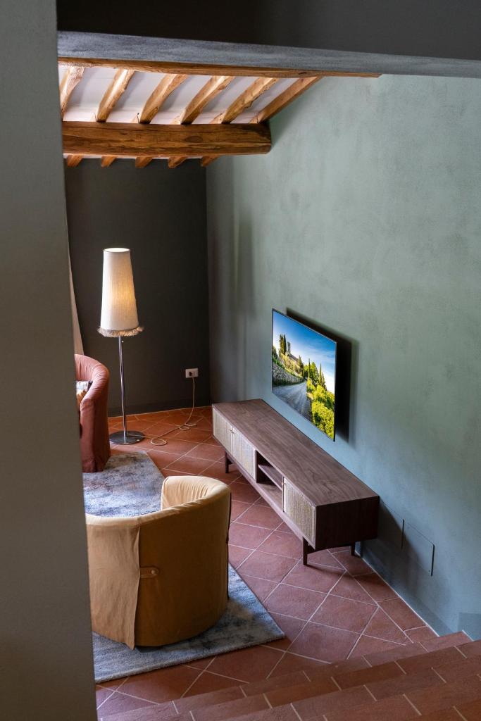 un salon avec une télévision à écran plat sur un mur dans l'établissement Casa Pernice, with private pool, à Gaiole in Chianti