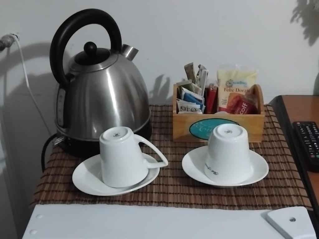 une bouilloire et deux tasses sur une table dans l'établissement Hotel Turano, à Castel di Tora