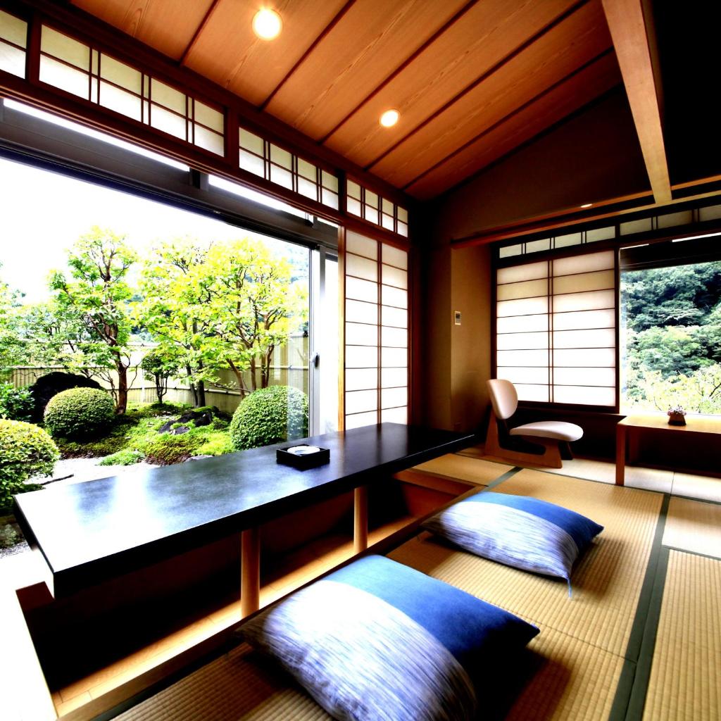 une pièce avec deux oreillers et une grande fenêtre dans l'établissement Hotel Okuyumoto, à Hakone