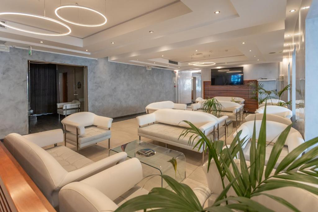 une salle d'attente avec des meubles blancs et des plantes dans l'établissement Club Hotel, à Riccione