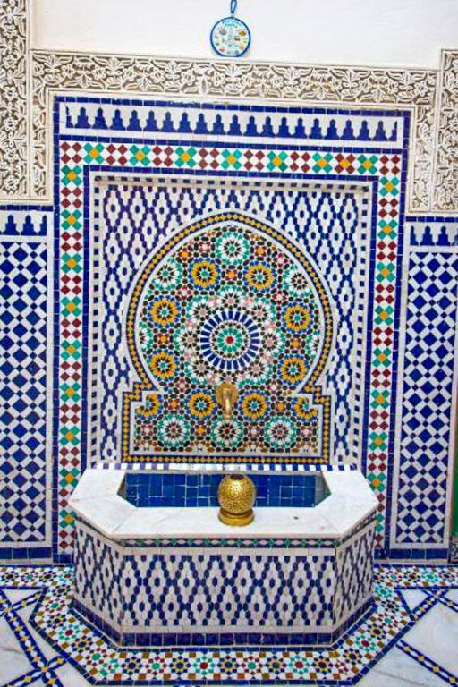 Cette chambre est dotée d'un mur en carrelage et d'une baignoire. dans l'établissement Riad Rayhana, à Fès