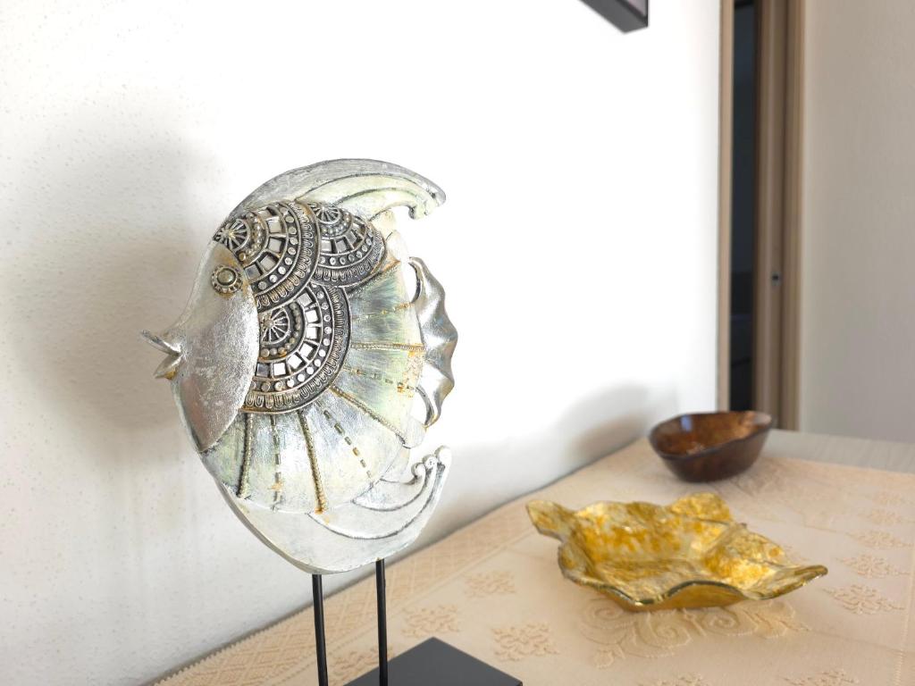un ornement d'oiseau en argent sur une table avec une assiette dans l'établissement Villetta Lucy - Budoni Sweet Home, à Tanaunella