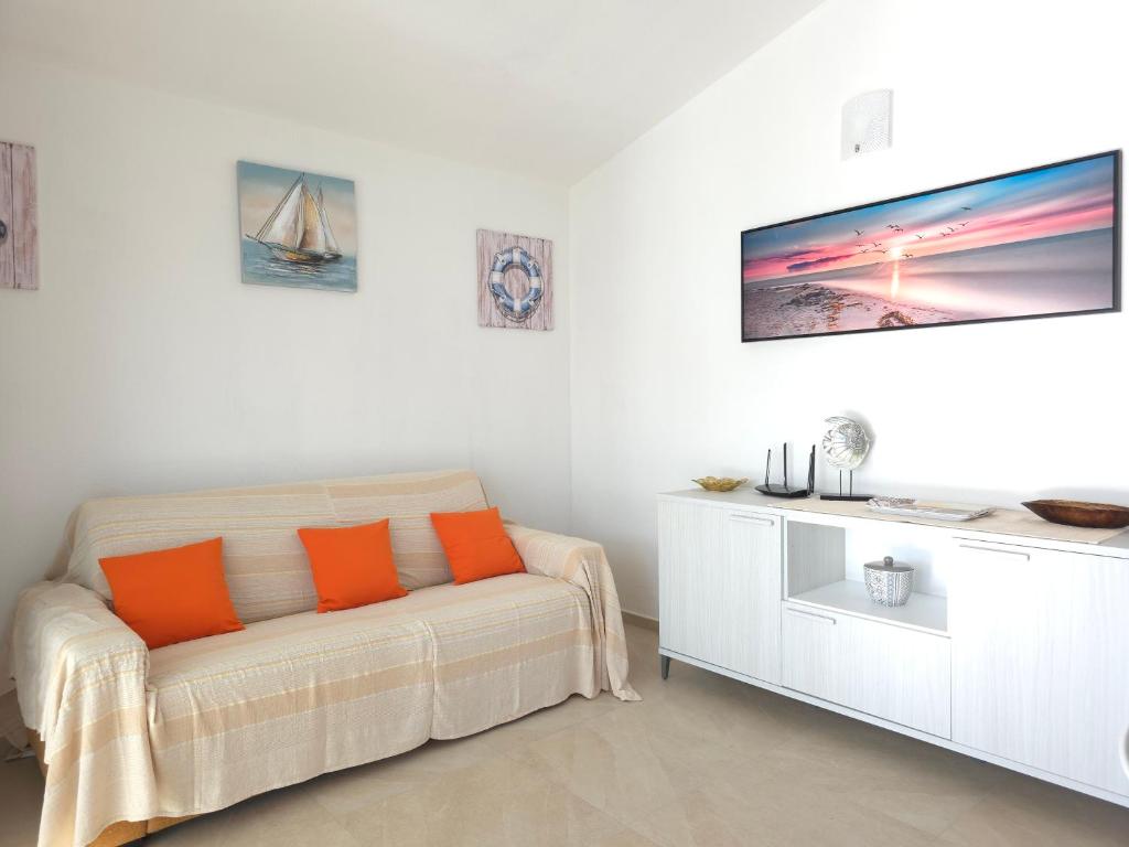 un salon blanc avec un canapé et une télévision dans l'établissement Villetta Lucy - Budoni Sweet Home, à Tanaunella