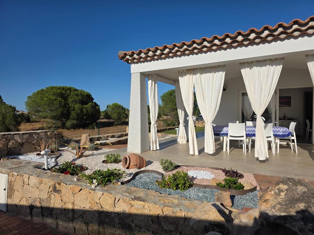 une arrière-cour avec un mur en pierre et une terrasse dans l'établissement Villetta Lucy - Budoni Sweet Home, à Tanaunella