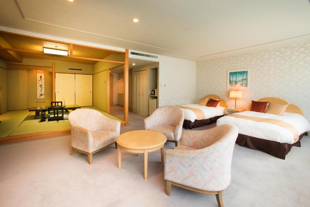 une chambre d'hôtel avec deux lits, une table et des chaises dans l'établissement Kinugawa Onsen Sanraku, à Nikkō