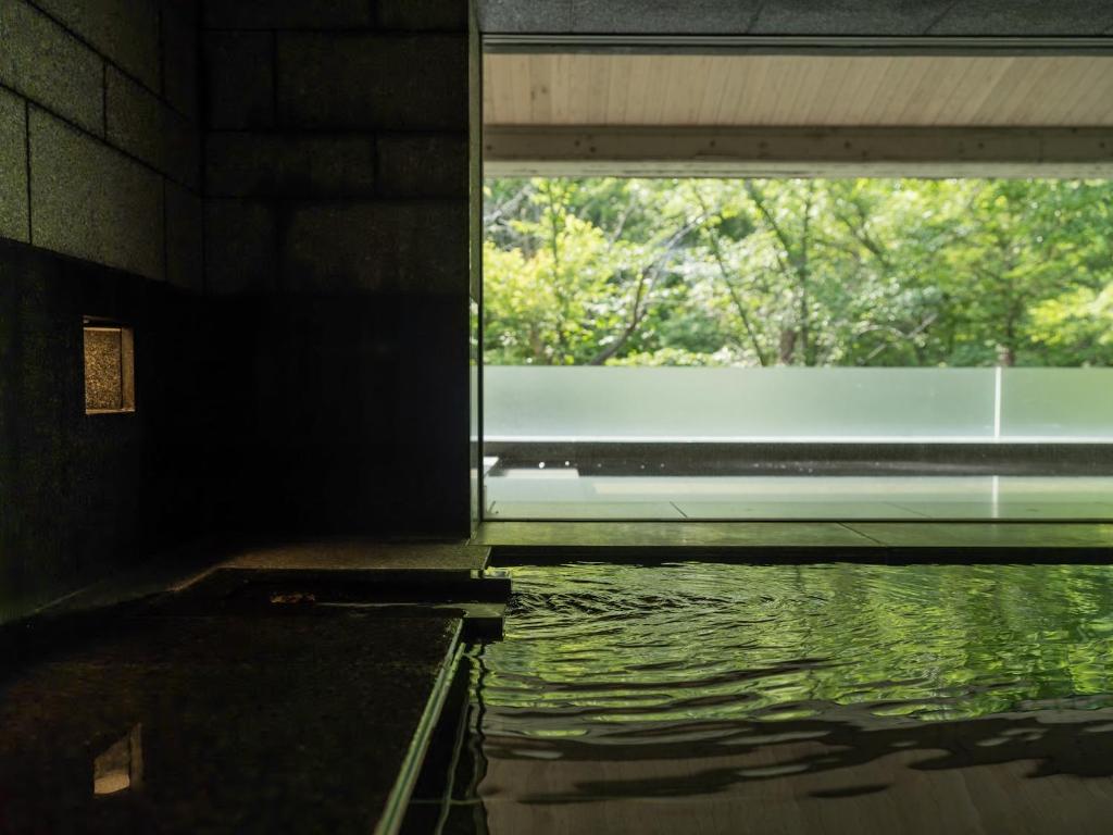 - une piscine d'eau dans une chambre avec fenêtre dans l'établissement 小樽旅亭 蔵群, à Otaru