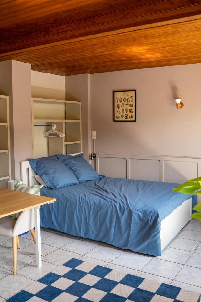 - une chambre avec un lit bleu et un plafond en bois dans l'établissement Flower Camping La Sténiole, à Granges-sur-Vologne