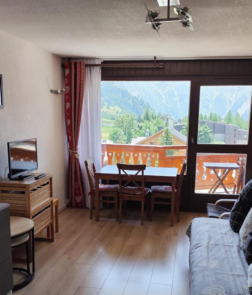 un salon avec une table et une grande fenêtre dans l'établissement résidence Plein Sud à côté Jandri express, front de neige, vue splendide, Label 2 Alpes, classé 2 étoiles Tourisme, à Les Deux Alpes 15 autres photos