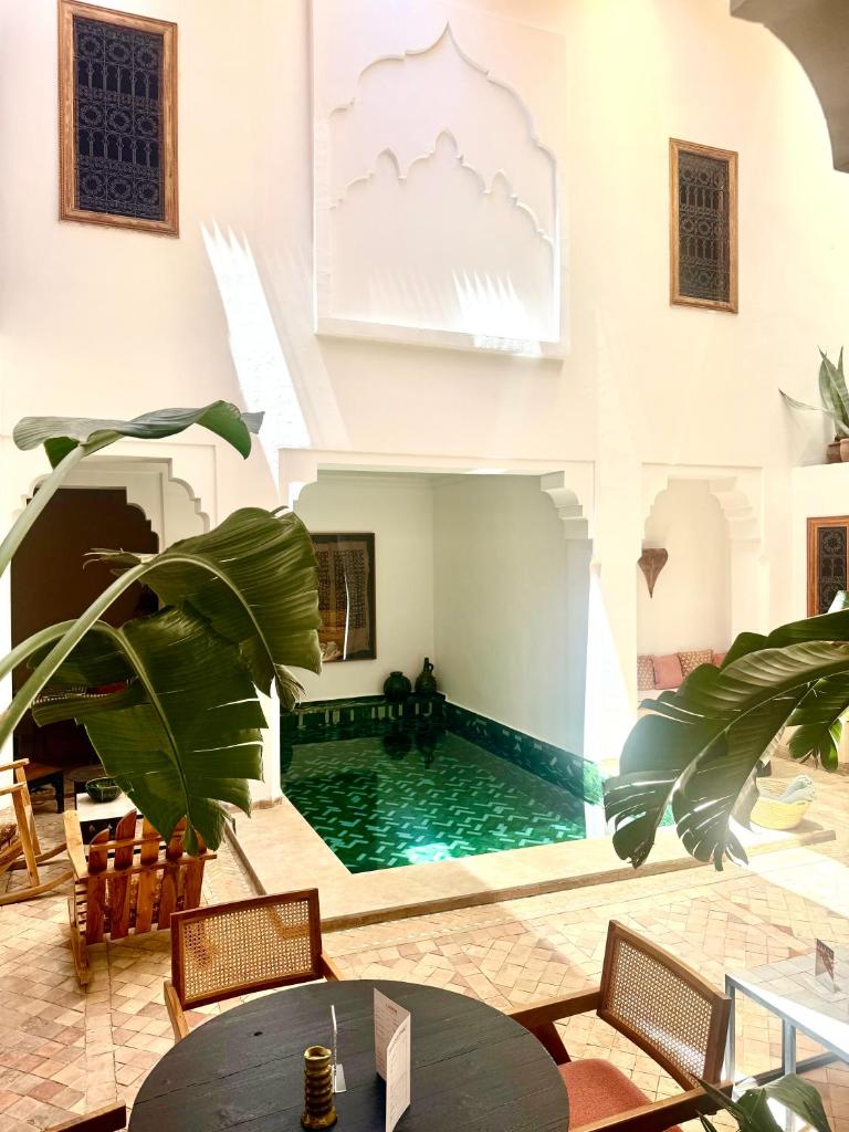 - une piscine dans une pièce avec une table et des chaises dans l'établissement Riad RK Suites & Spa, à Marrakech