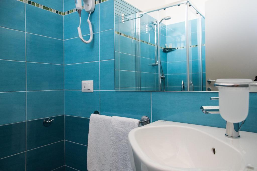 une salle de bain bleue avec un lavabo et un miroir dans l'établissement Hotel Mirage, à Bellaria-Igea Marina