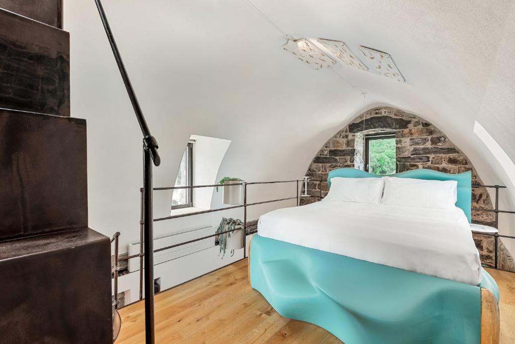 un lit dans une chambre avec un mur de briques dans l'établissement Capitolare Suite Tower, à Portovenere