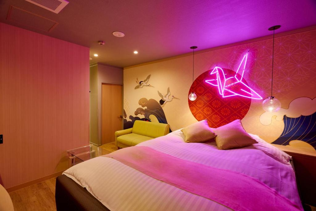 - une chambre avec un lit à éclairage violet dans l'établissement Asahikawa Hotel 818-Adult Only, à Asahikawa