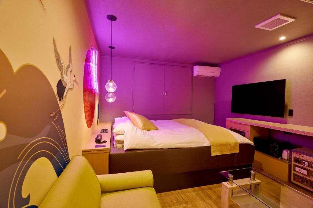 Cette chambre violette comprend un lit et une télévision. dans l'établissement Asahikawa Hotel 818-Adult Only, à Asahikawa